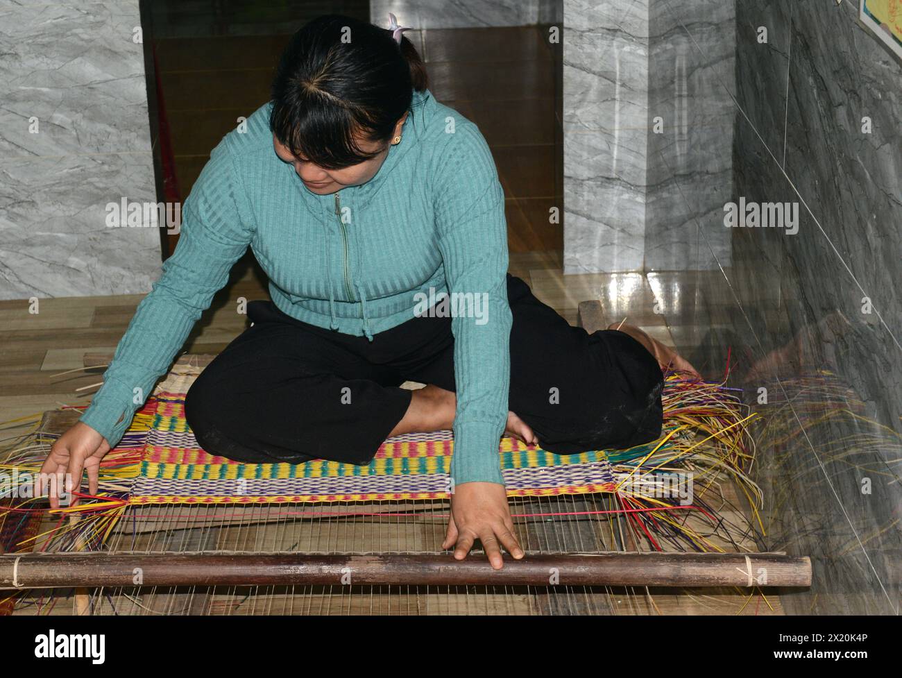 Un tessitore di tappeti che lavora nella sua casa in un piccolo villaggio a Cẩm Kim, Hội An, Vietnam. Foto Stock