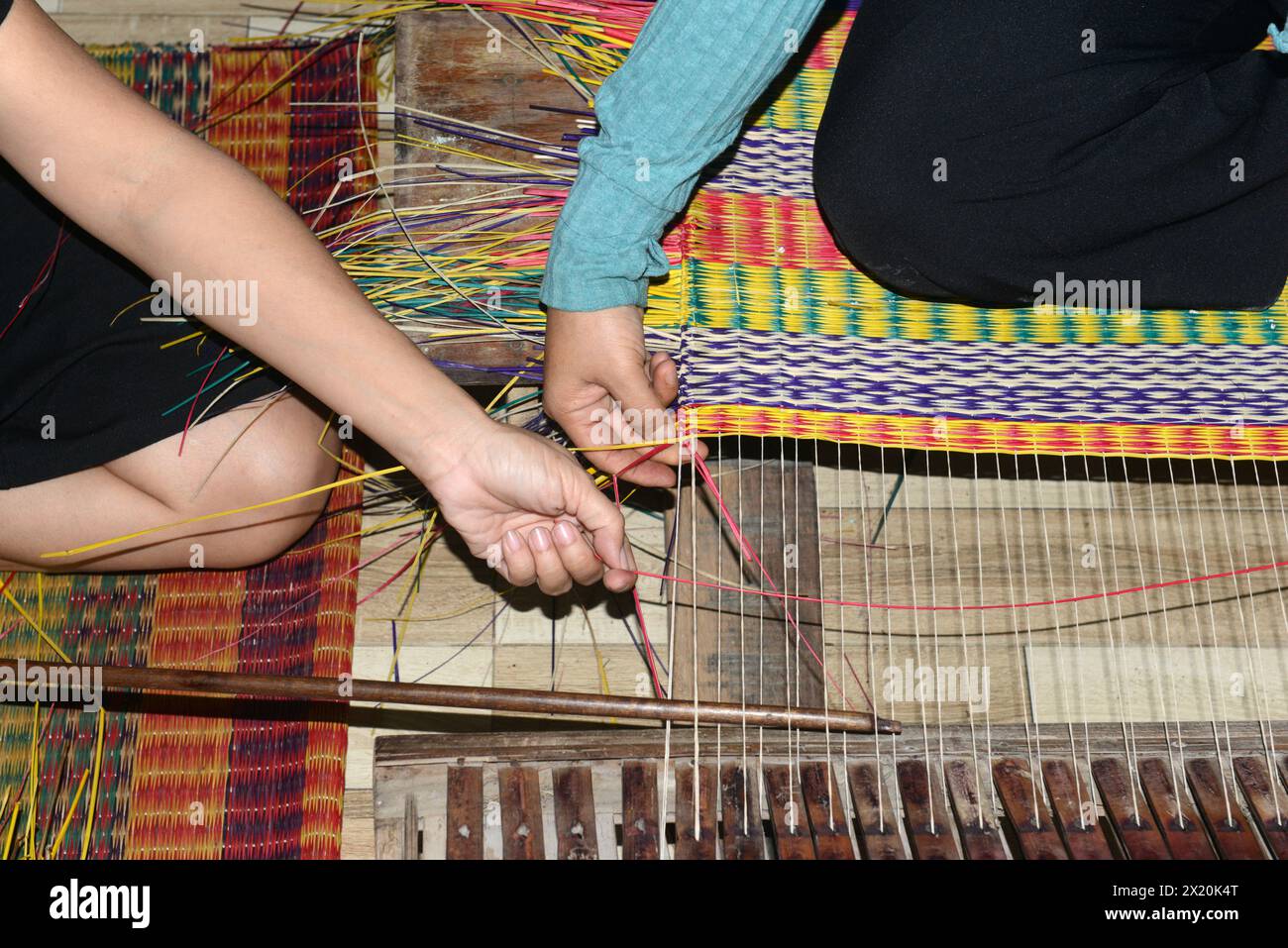 Un tessitore di tappeti che lavora nella sua casa in un piccolo villaggio a Cẩm Kim, Hội An, Vietnam. Foto Stock
