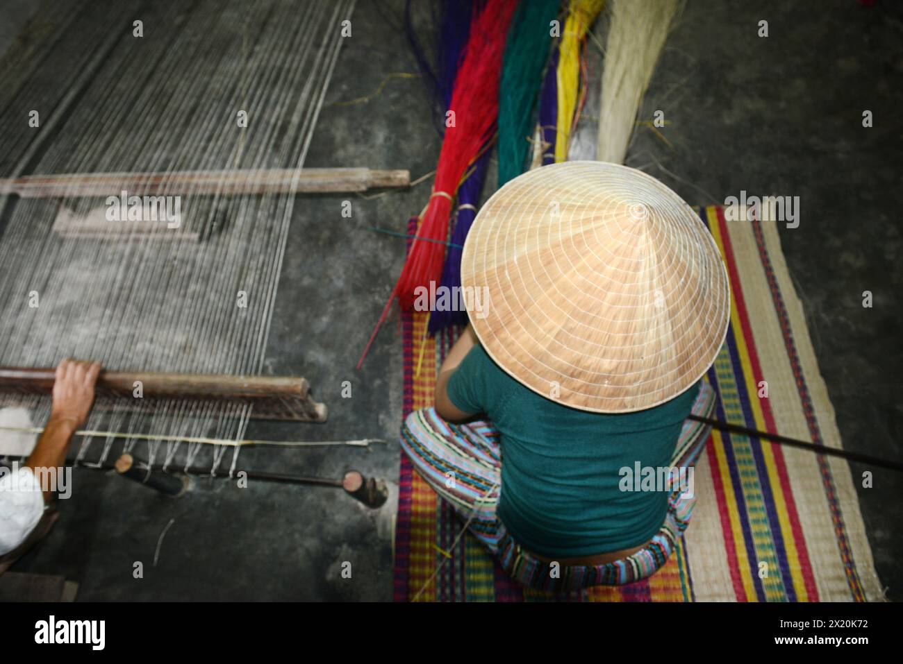 Un tessitore di tappeti che lavora nella sua casa in un piccolo villaggio a Cẩm Kim, Hội An, Vietnam. Foto Stock