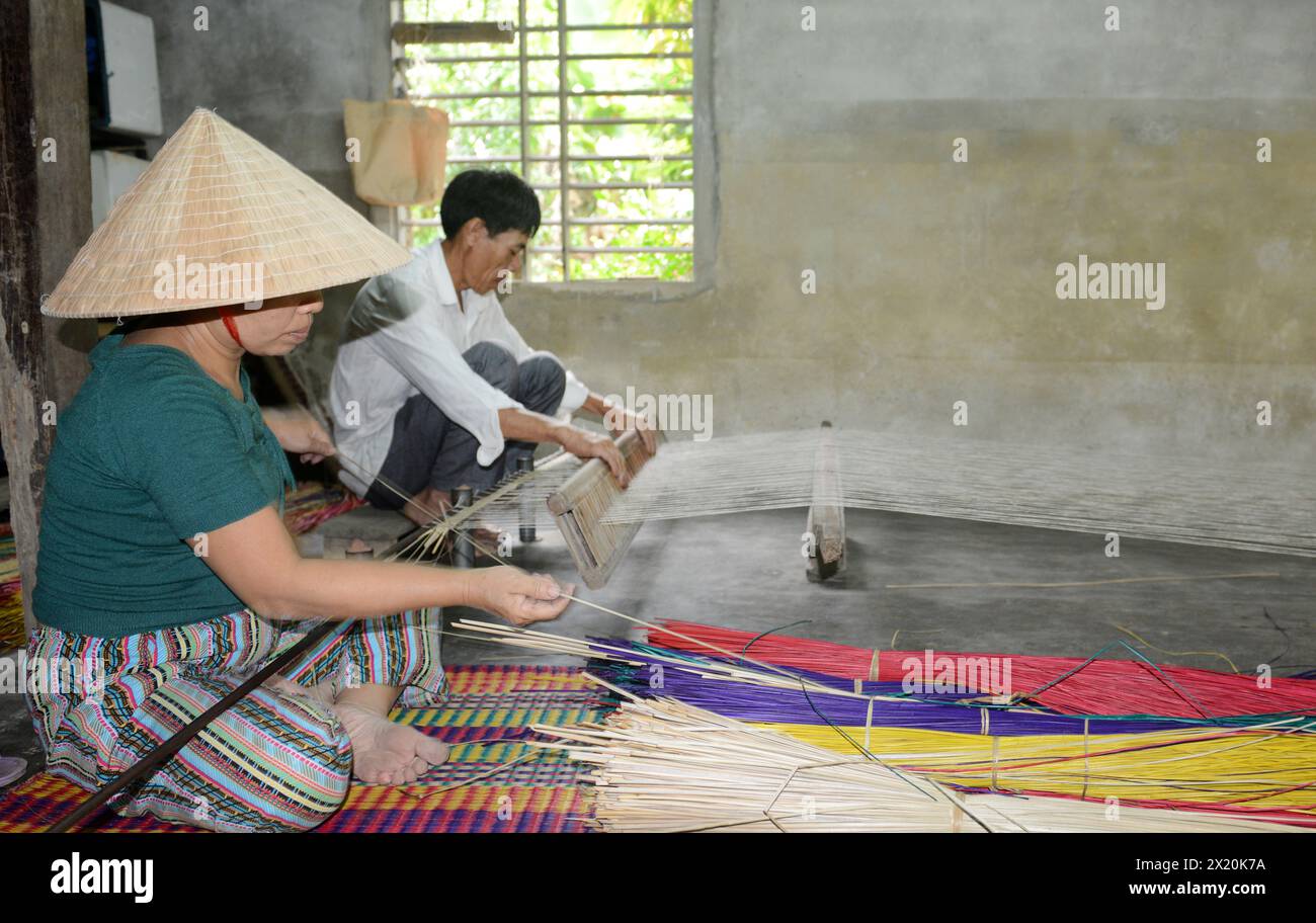 Un tessitore di tappeti che lavora nella sua casa in un piccolo villaggio a Cẩm Kim, Hội An, Vietnam. Foto Stock