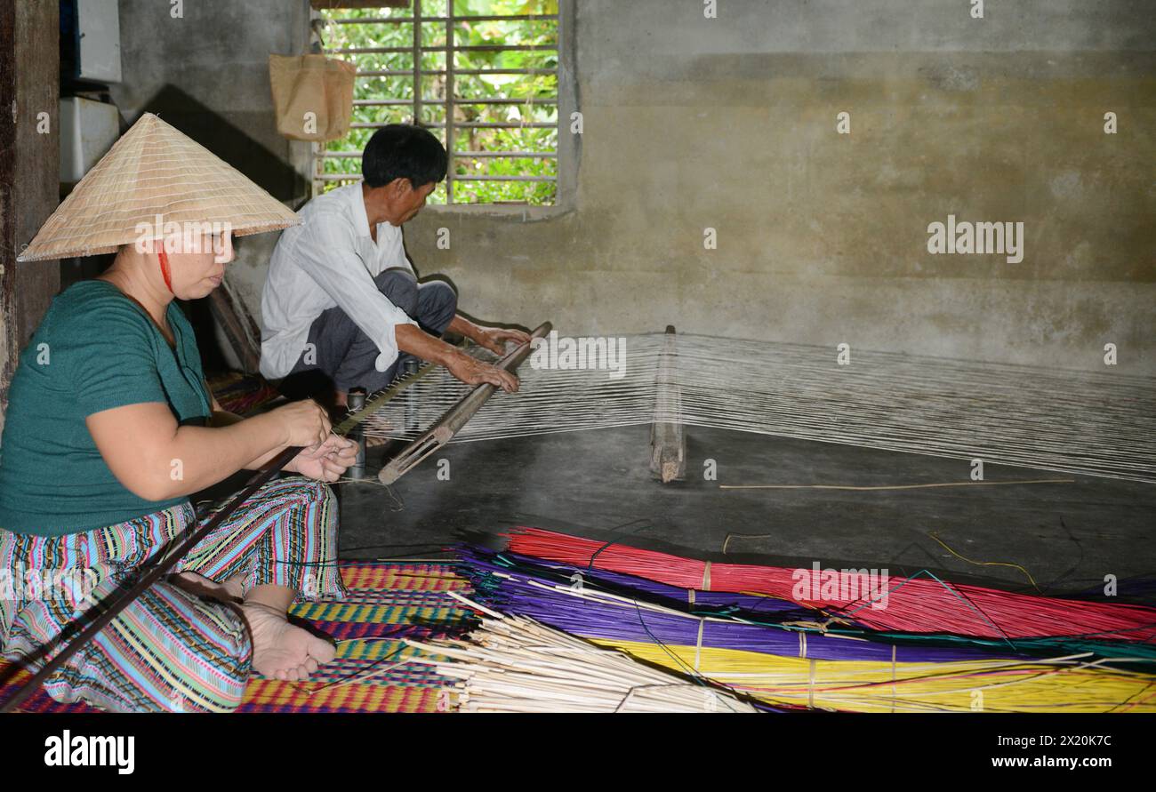 Un tessitore di tappeti che lavora nella sua casa in un piccolo villaggio a Cẩm Kim, Hội An, Vietnam. Foto Stock