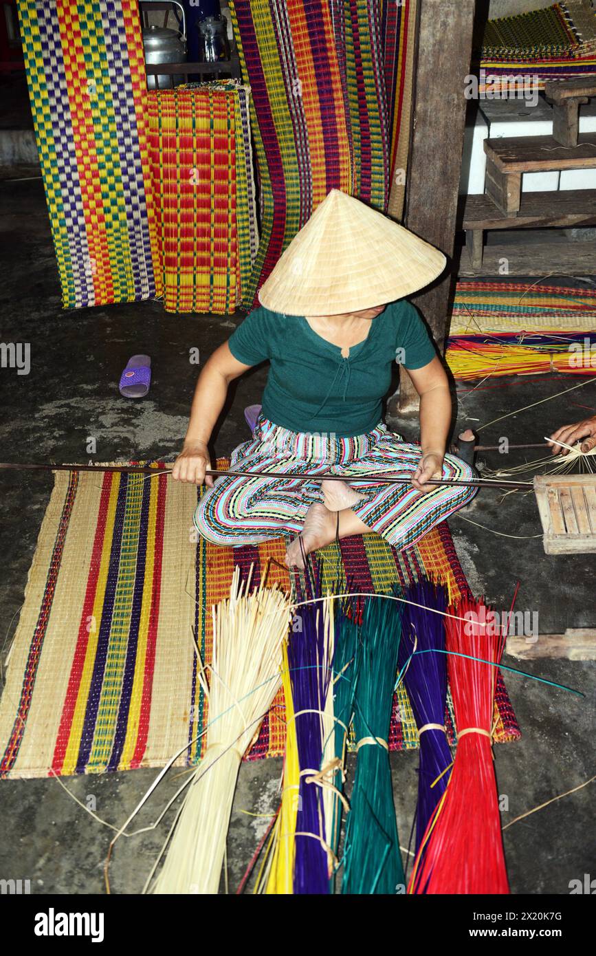 Un tessitore di tappeti che lavora nella sua casa in un piccolo villaggio a Cẩm Kim, Hội An, Vietnam. Foto Stock