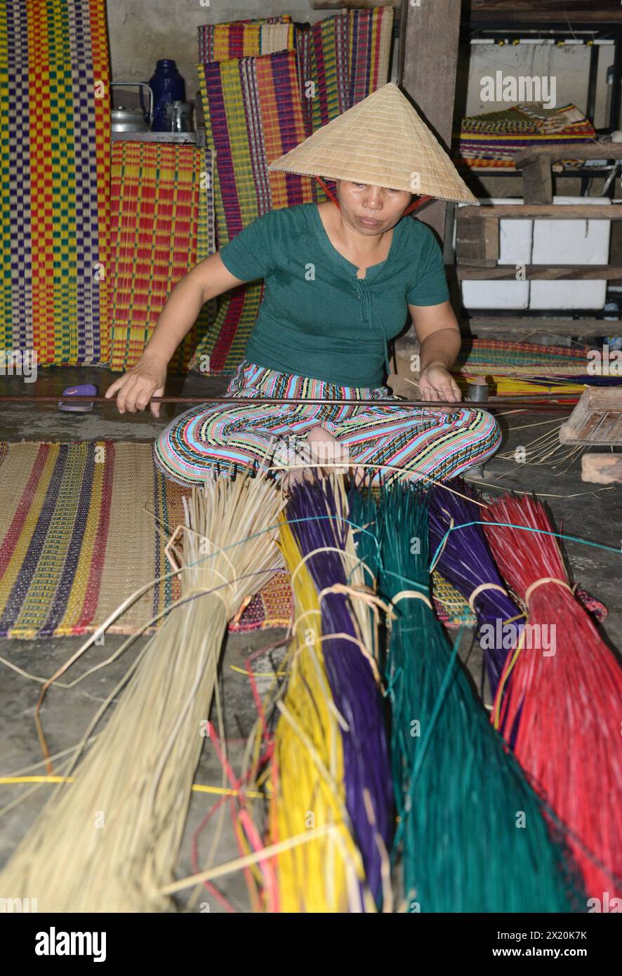 Un tessitore di tappeti che lavora nella sua casa in un piccolo villaggio a Cẩm Kim, Hội An, Vietnam. Foto Stock