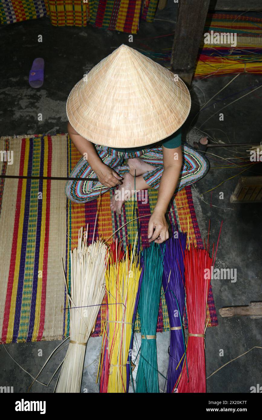 Un tessitore di tappeti che lavora nella sua casa in un piccolo villaggio a Cẩm Kim, Hội An, Vietnam. Foto Stock