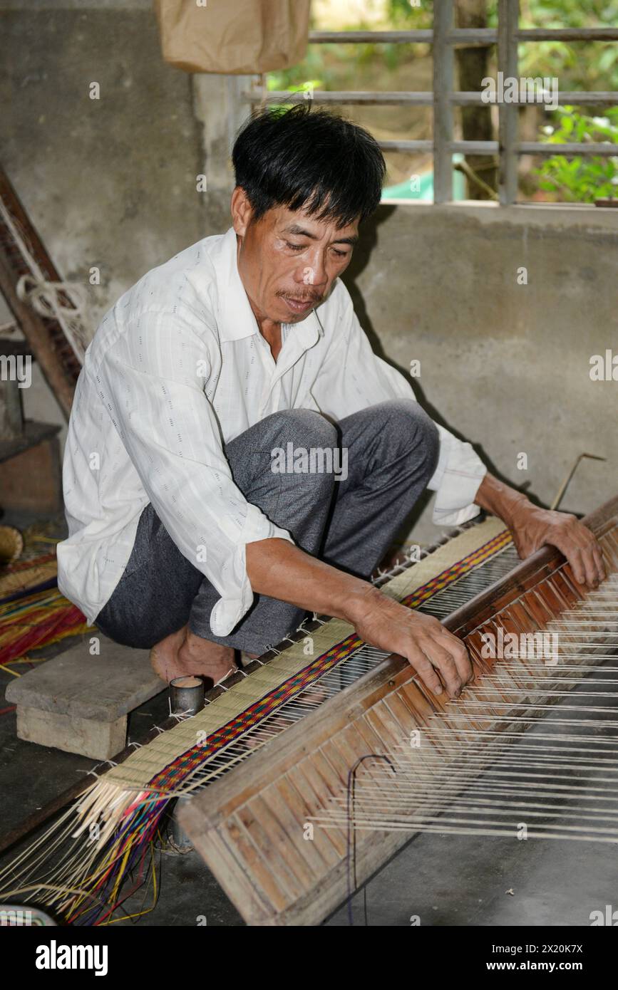Un tessitore di tappeti che lavora nella sua casa in un piccolo villaggio a Cẩm Kim, Hội An, Vietnam. Foto Stock