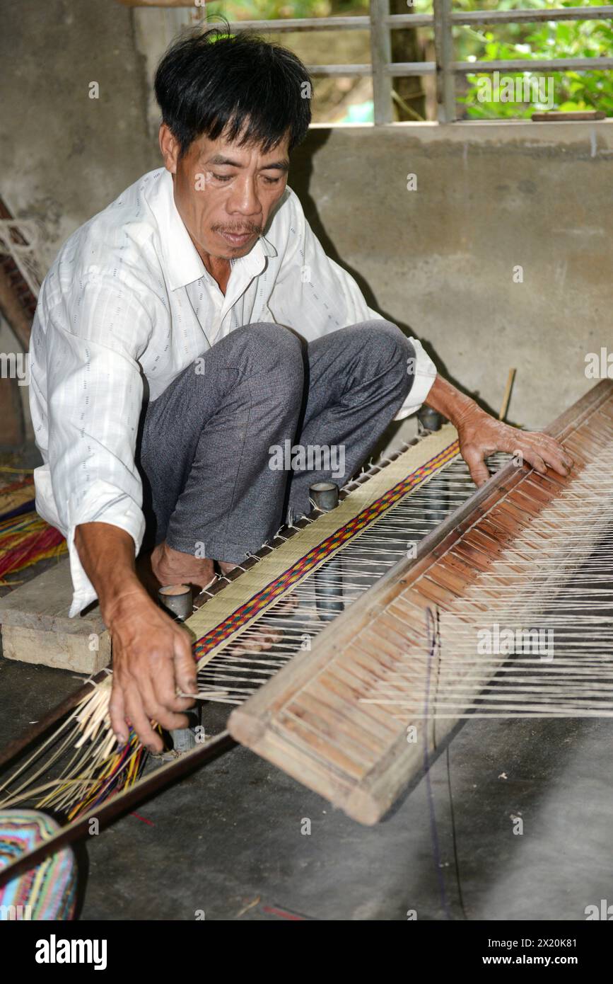 Un tessitore di tappeti che lavora nella sua casa in un piccolo villaggio a Cẩm Kim, Hội An, Vietnam. Foto Stock