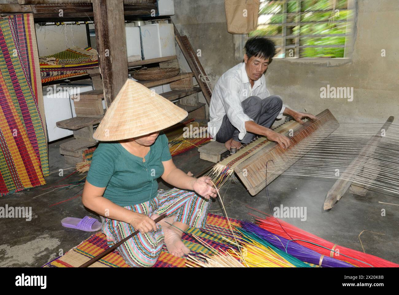 Un tessitore di tappeti che lavora nella sua casa in un piccolo villaggio a Cẩm Kim, Hội An, Vietnam. Foto Stock