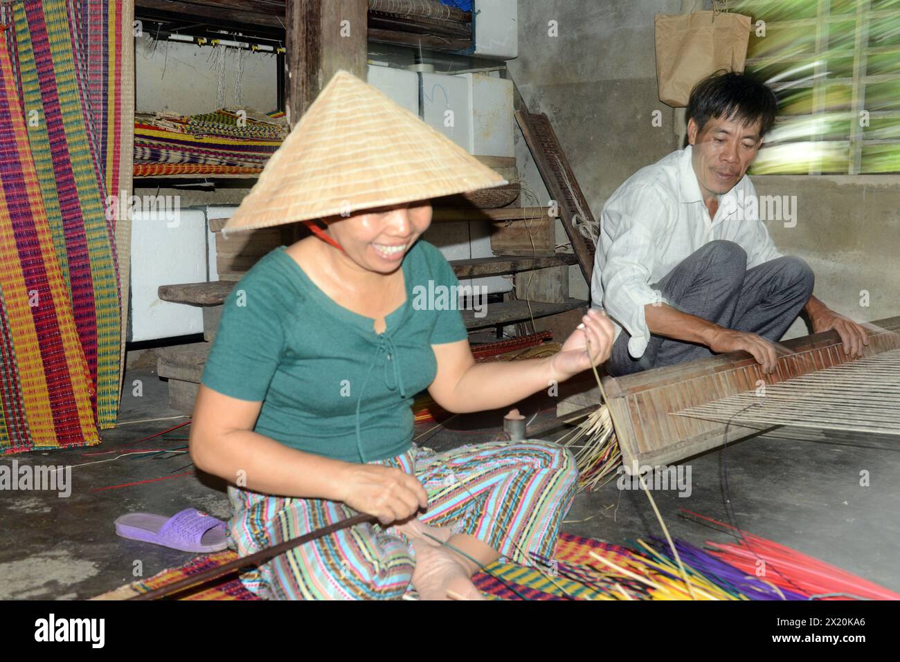 Un tessitore di tappeti che lavora nella sua casa in un piccolo villaggio a Cẩm Kim, Hội An, Vietnam. Foto Stock