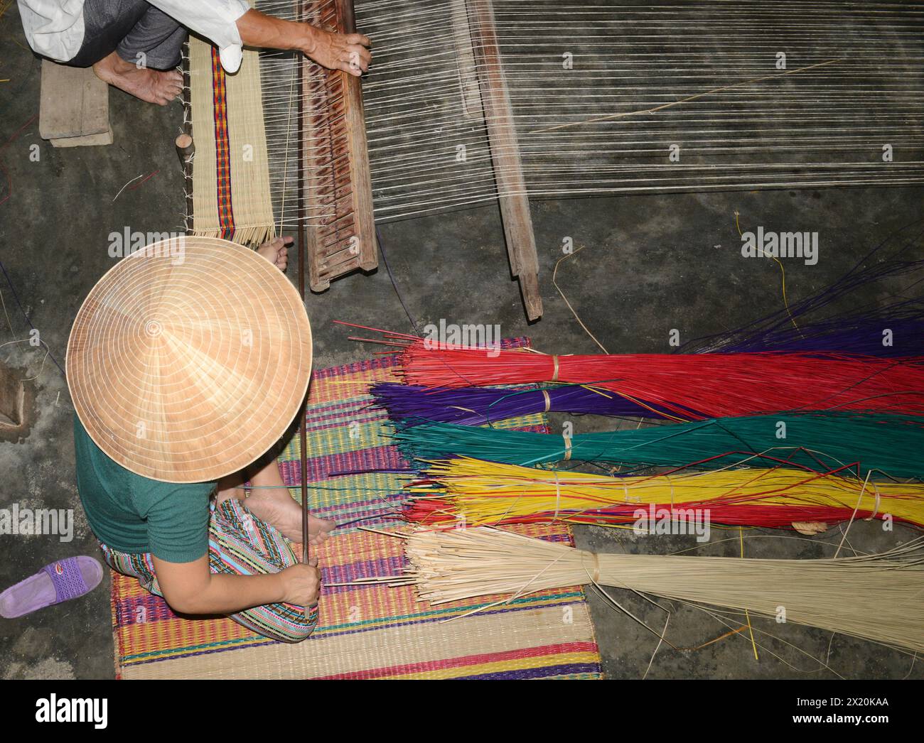 Un tessitore di tappeti che lavora nella sua casa in un piccolo villaggio a Cẩm Kim, Hội An, Vietnam. Foto Stock