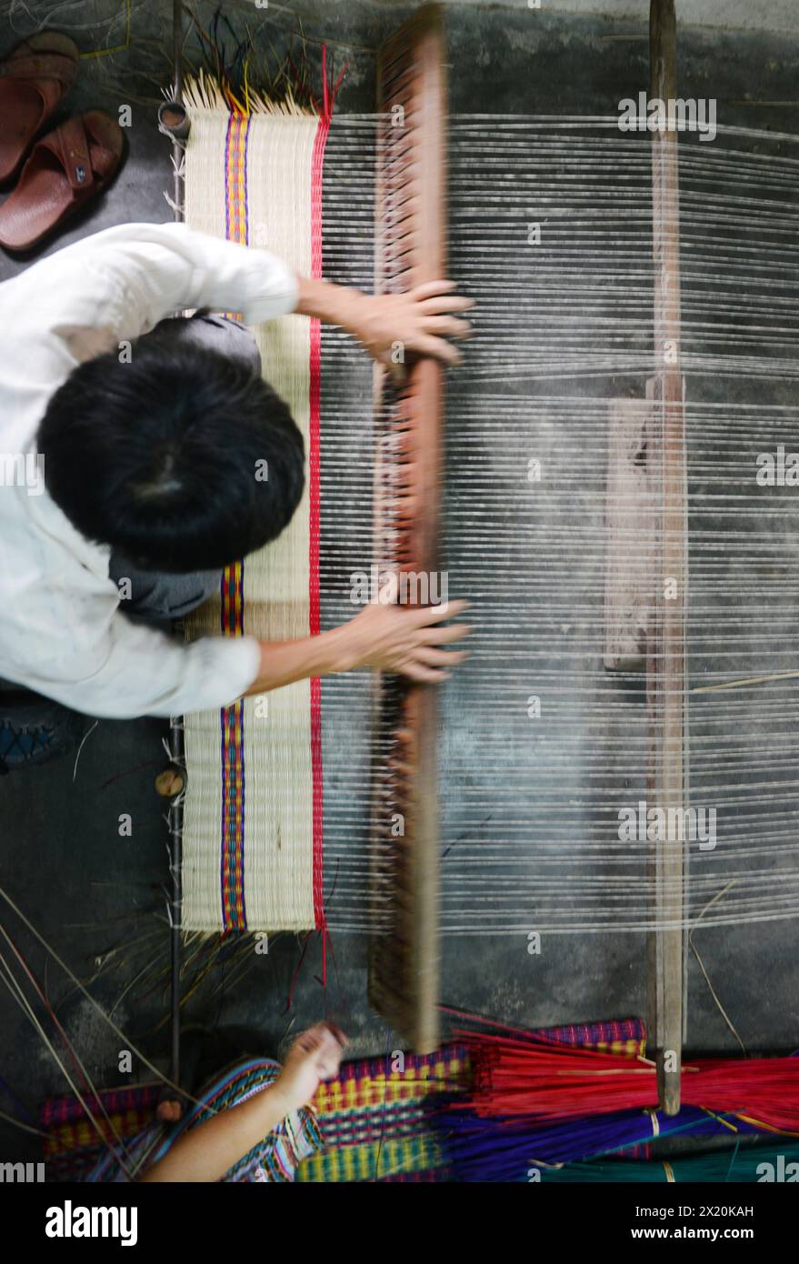 Un tessitore di tappeti che lavora nella sua casa in un piccolo villaggio a Cẩm Kim, Hội An, Vietnam. Foto Stock