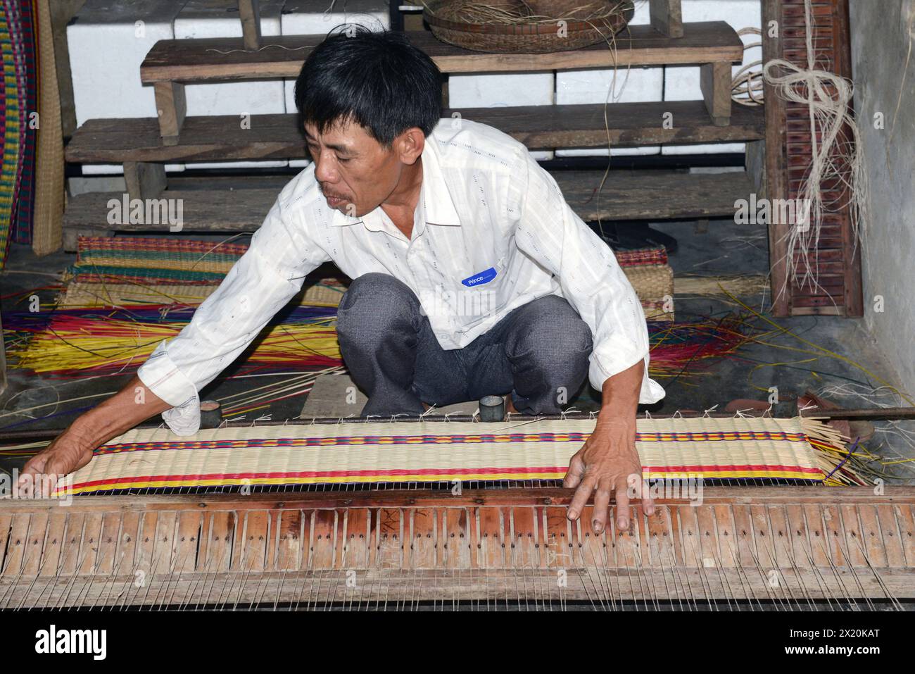 Un tessitore di tappeti che lavora nella sua casa in un piccolo villaggio a Cẩm Kim, Hội An, Vietnam. Foto Stock