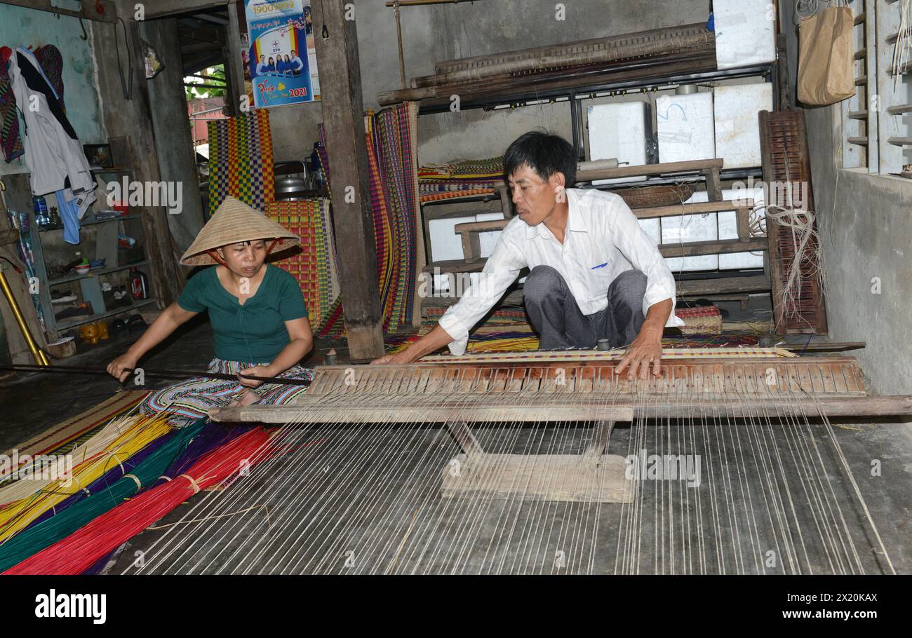 Un tessitore di tappeti che lavora nella sua casa in un piccolo villaggio a Cẩm Kim, Hội An, Vietnam. Foto Stock