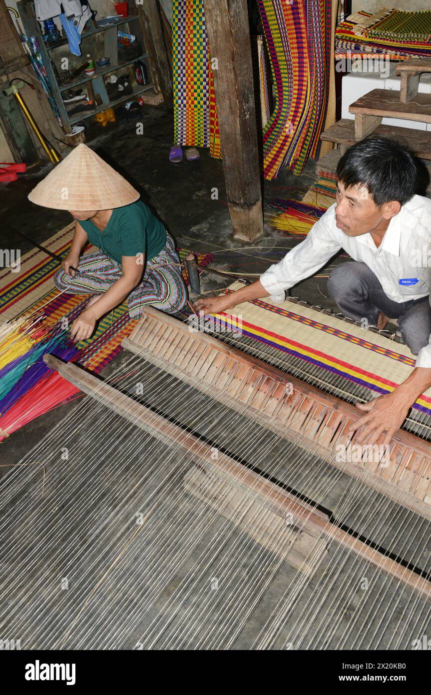 Un tessitore di tappeti che lavora nella sua casa in un piccolo villaggio a Cẩm Kim, Hội An, Vietnam. Foto Stock
