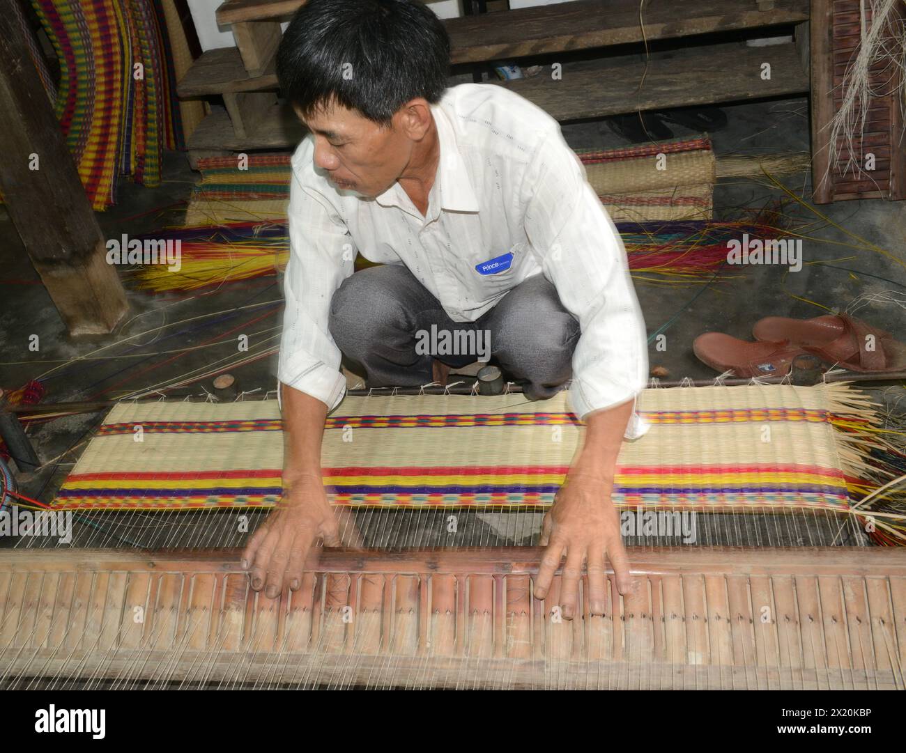 Un tessitore di tappeti che lavora nella sua casa in un piccolo villaggio a Cẩm Kim, Hội An, Vietnam. Foto Stock