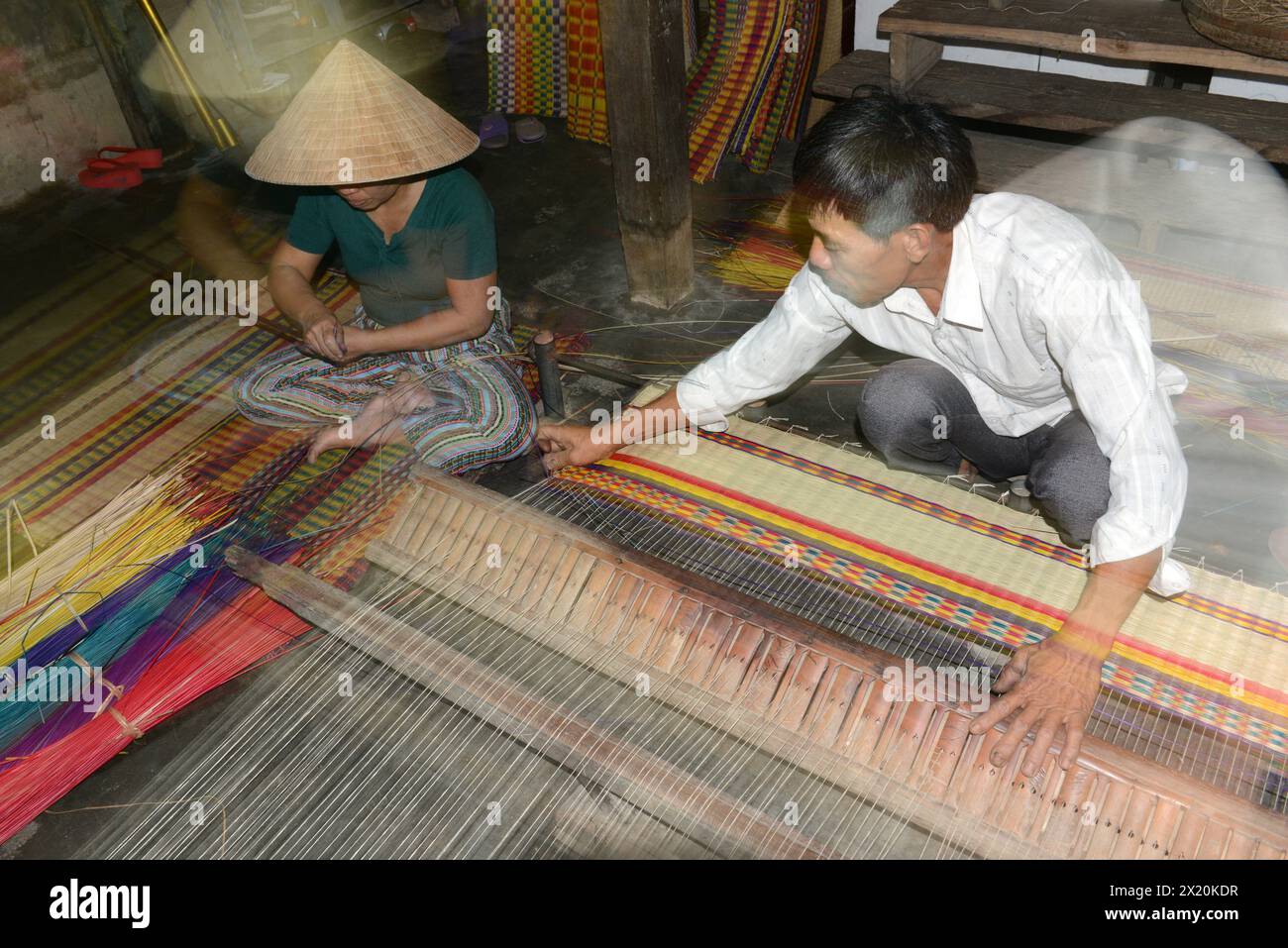 Un tessitore di tappeti che lavora nella sua casa in un piccolo villaggio a Cẩm Kim, Hội An, Vietnam. Foto Stock