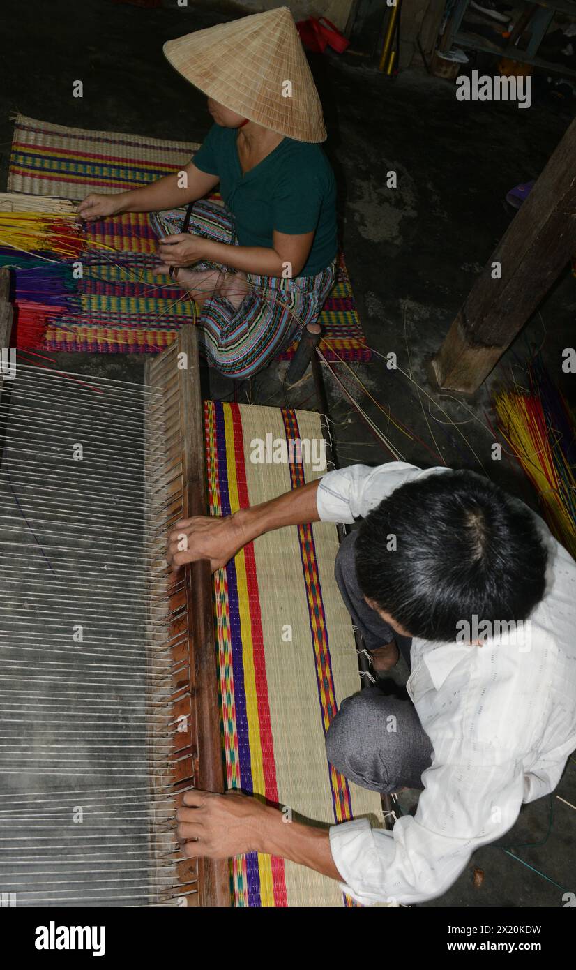 Un tessitore di tappeti che lavora nella sua casa in un piccolo villaggio a Cẩm Kim, Hội An, Vietnam. Foto Stock