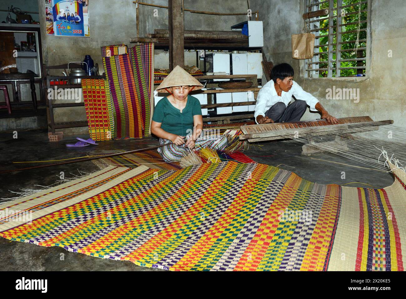Un tessitore di tappeti che lavora nella sua casa in un piccolo villaggio a Cẩm Kim, Hội An, Vietnam. Foto Stock