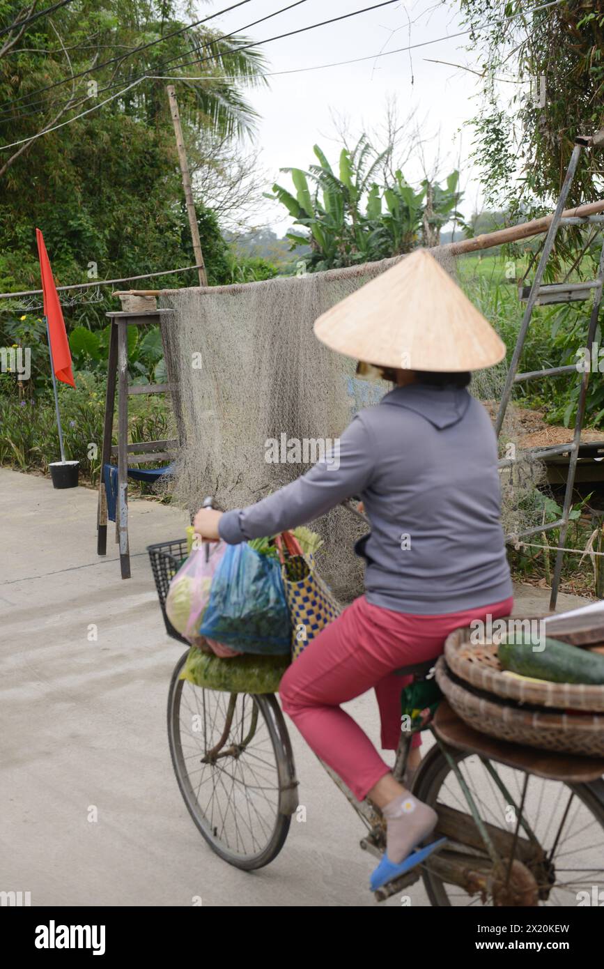 Una donna vietnamita che pedala con una grande rete da pesca a Bàn Thạch, Hoi An, Vietnam. Foto Stock