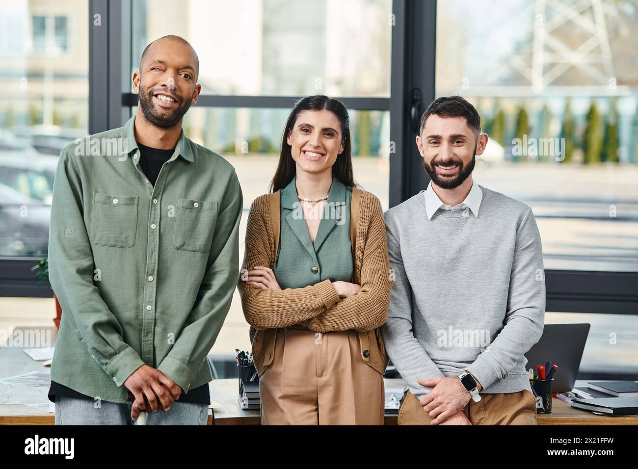 Tre persone, impegnate nella discussione, si riuniscono in un ufficio, incarnando la collaborazione aziendale e l'innovazione. Foto Stock