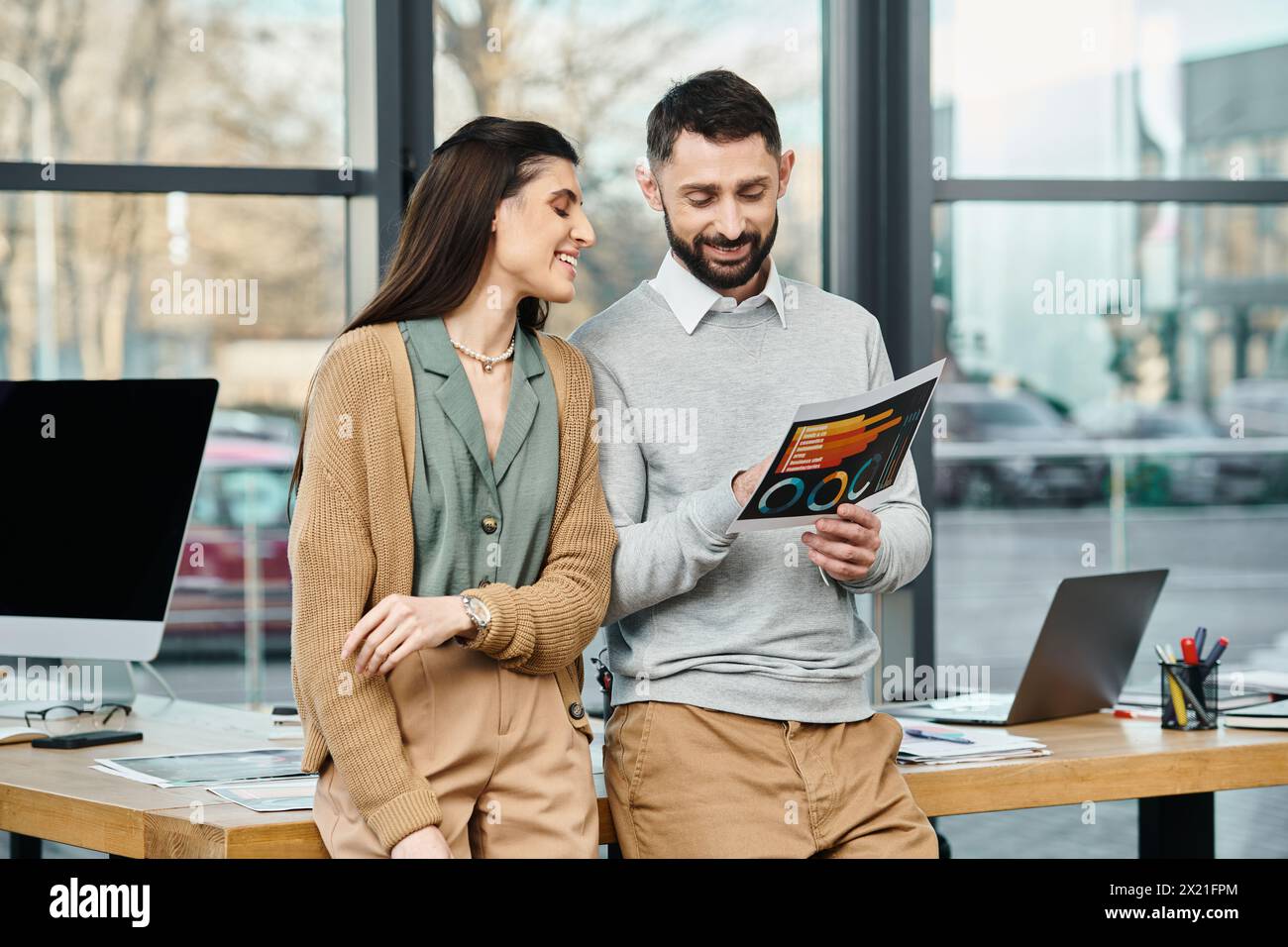 Un uomo e una donna coinvolti in una cartella, le loro menti catturate dalle parole sulla pagina. Foto Stock