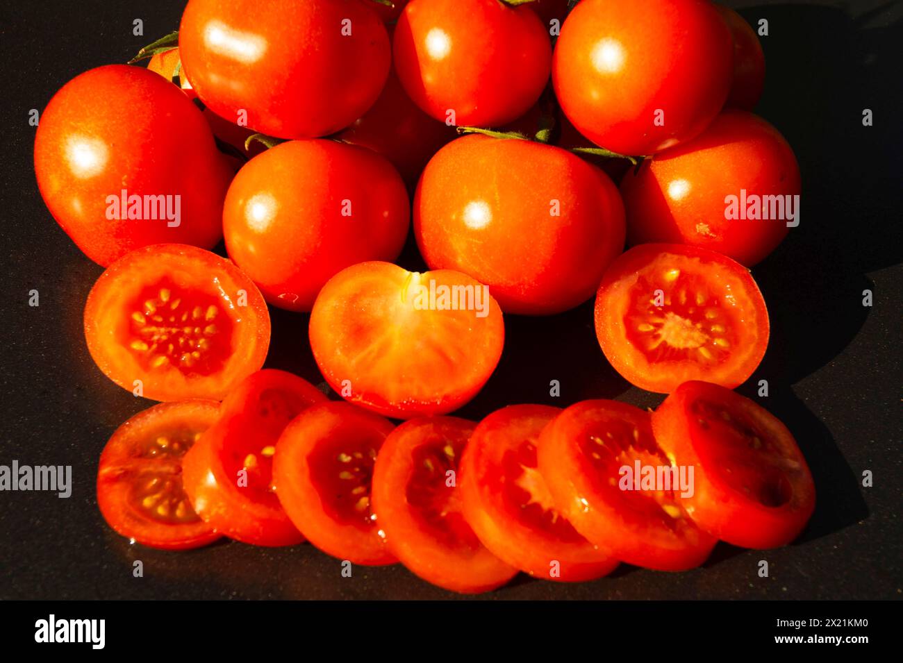 Pomodoro da giardino (Solanum lycopersicum, Lycopersicon esculentum), pomodori freschi, interi, tagliati a metà e tagliati a fette Foto Stock