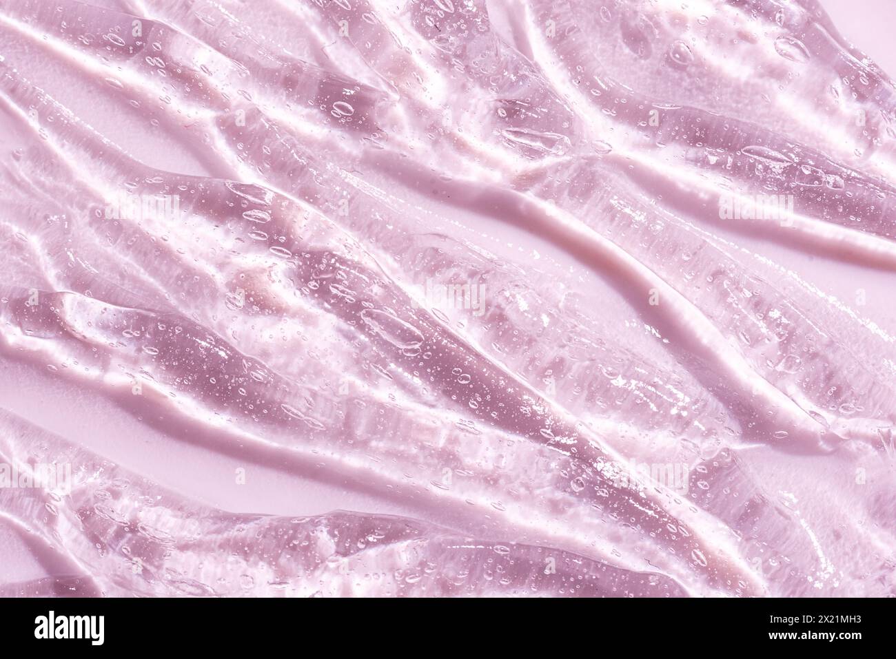 Siero di acido ialuronico con bolle di ossigeno o gel di collagene per idratazione cutanea. Primo piano sulla consistenza del gel cosmetico su sfondo rosa. Foto Stock