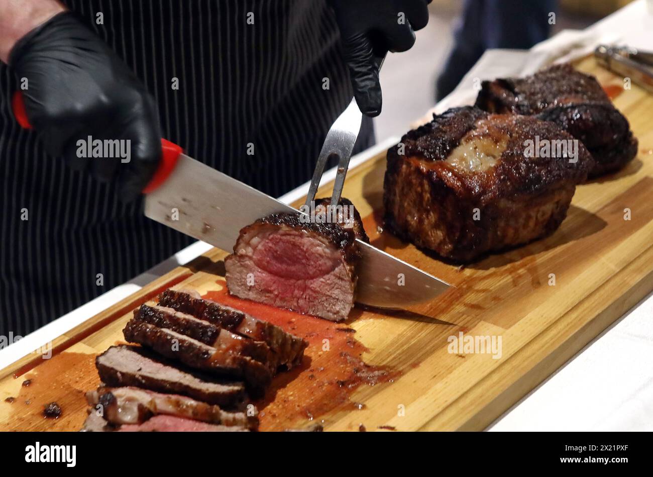 Non esclusiva: KIEV, UCRAINA - 17 APRILE 2024 - Chef fette di carne cucinata in stile argentino per gli ospiti di un evento di gala organizzato dall'Ambasciata del Foto Stock