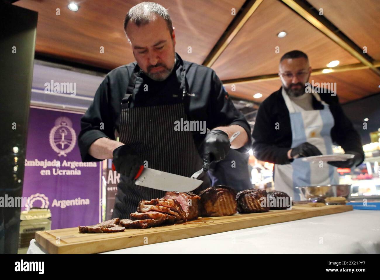 Non esclusiva: KIEV, UCRAINA - 17 APRILE 2024 - Chef fette di carne cucinata in stile argentino per gli ospiti di un evento di gala organizzato dall'Ambasciata del Foto Stock