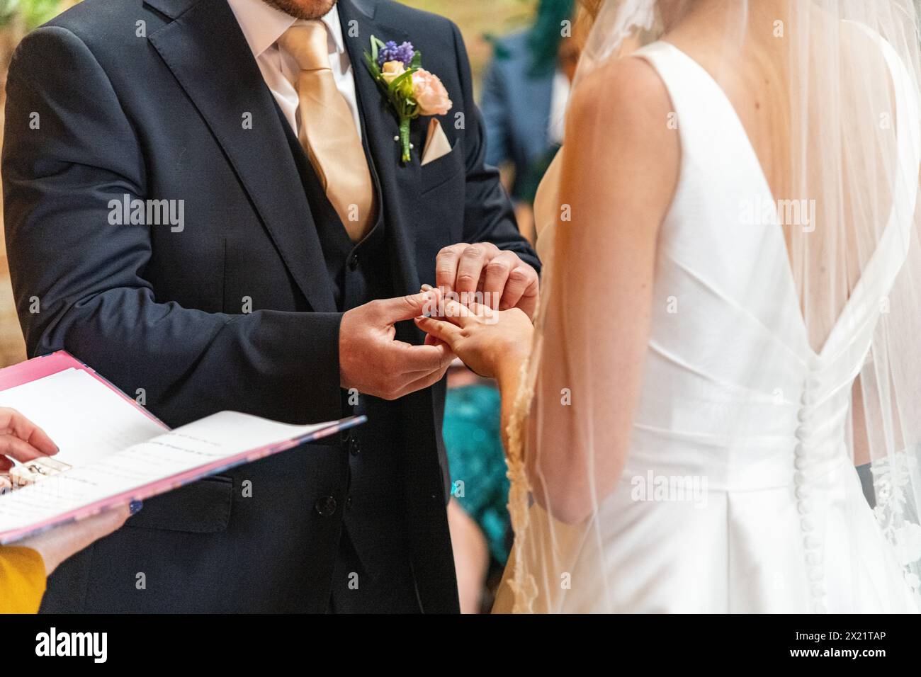 Una coppia di sposi che si scambiava i voti e gli anelli di nozze durante una cerimonia di servizio durante un matrimonio alla Botley Hill Farm nel Surrey, Regno Unito Foto Stock