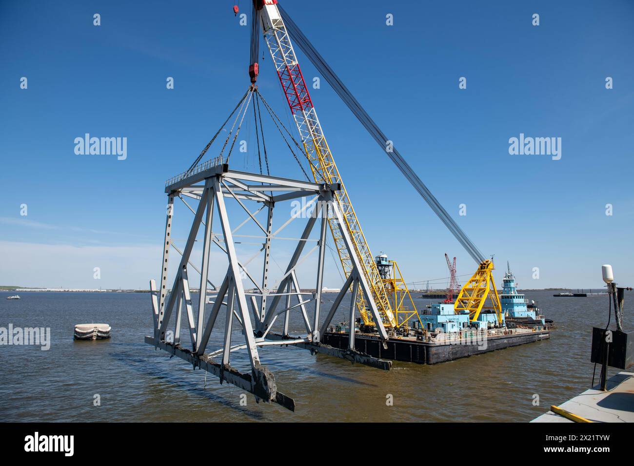 Dundalk, Stati Uniti d'America. 16 aprile 2024. La Chesapeake, una chiatta di derrick con capacità di 1000 tonnellate, solleva una sezione del crollato Francis Scott Key Bridge bloccando il canale di Fort McHenry, il 16 aprile 2024, vicino a Dundalk, Maryland. Il ponte fu colpito dalla nave portacontainer di 984 piedi il 26 marzo e crollò uccidendo sei lavoratori. Crediti: MC2 Christine Montgomery/US Navy Photo/Alamy Live News Foto Stock