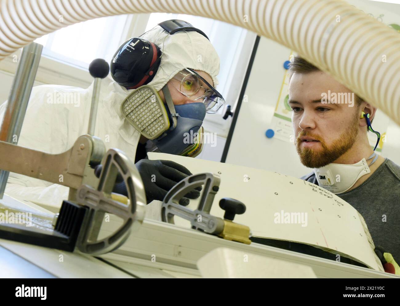 12 aprile 2024, Sassonia, Lipsia: Nel centro tecnico del campus dell'Università di scienze applicate (HTWK), gli assistenti alla ricerca Dimitrij Seibert e Philipp Johst del gruppo guidato dal professore HTWK di costruzione leggera con materiali compositi Böhm stanno preparando una piccola parte di una lunghezza di 19,3 metri, pala del rotore di turbina eolica vecchia di 25 anni per la frantumazione per una prova per determinarne le proprietà meccaniche. I test fanno parte di EuReCOMP, un progetto di ricerca collaborativo finanziato dall'UE che mira a sviluppare metodi sostenibili per il riciclaggio e il riutilizzo di materiali compositi provenienti da impianti eolici Foto Stock