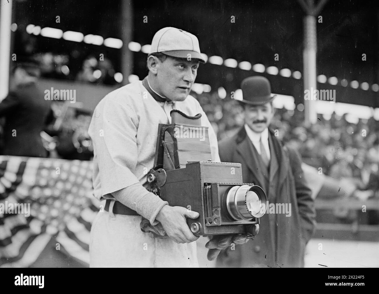 Germany Schaefer, Washington AL (baseball), 1911. Mostra Herman A. "Germany" Schaefer (1876-1919), uno dei personaggi più divertenti della storia del baseball, provando l'altro lato della telecamera durante la visita dei Washington Senators per giocare ai New York Highlanders nell'aprile 1911. Germany Schaefer, un versatile interno e veloce baserunner, giocò la maggior parte della sua carriera con i Detroit Tigers e i Washington Senators. La fotocamera è un 5x7 Press Graflex con una modifica per alloggiare l'obiettivo grande. La telecamera è stata prodotta dalla Folmer &amp; Schwing Division della Eastman Kodak Co Foto Stock