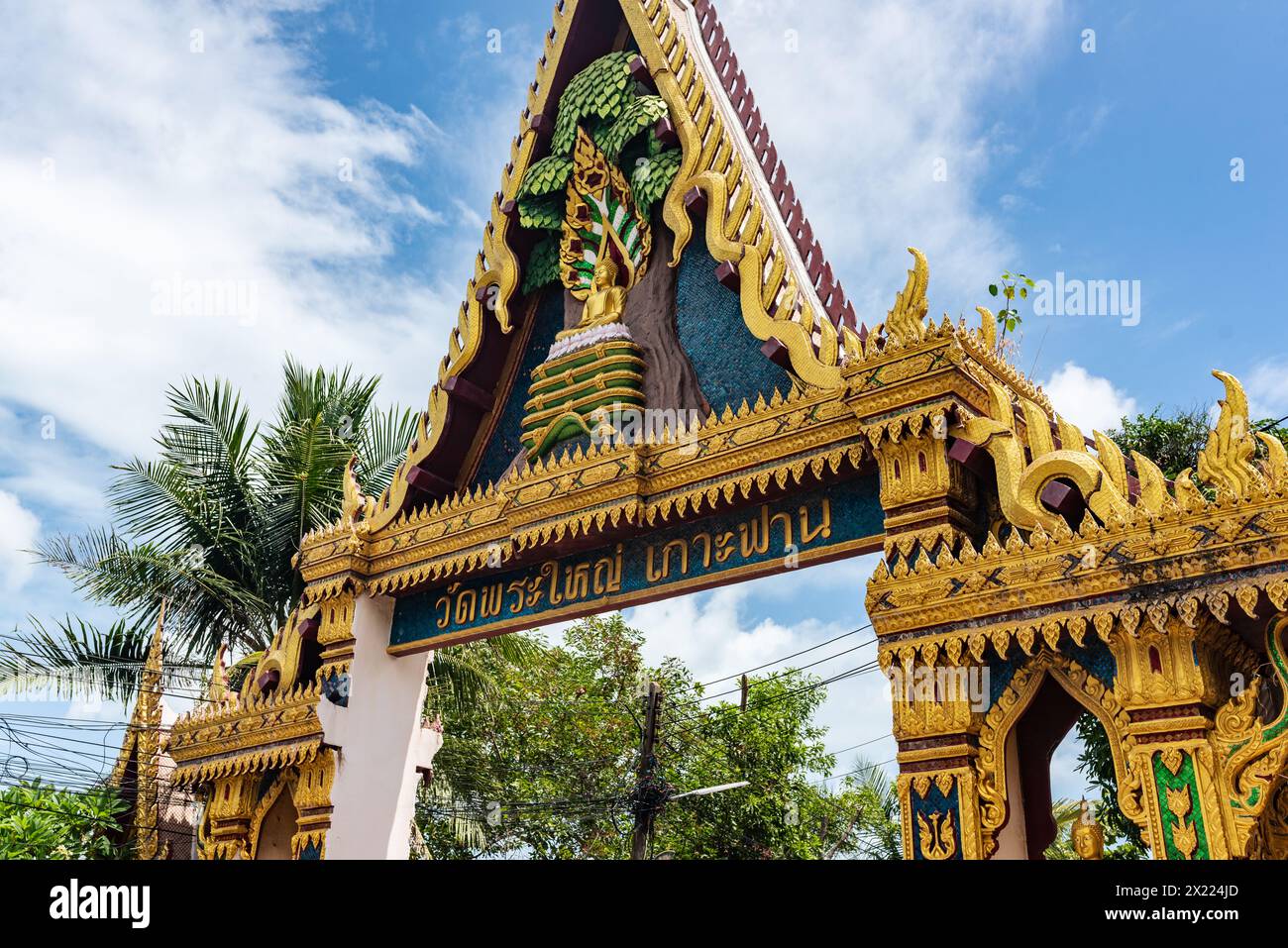 L'intricata porta d'ingresso di un tempio a Koh Samui, adornata con motivi dorati e tradizionale scrittura thailandese. Foto Stock
