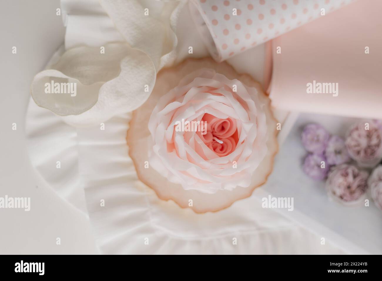 candela fatta a mano a forma di fiore su sfondo chiaro, spazio per testo. Foto di alta qualità Foto Stock