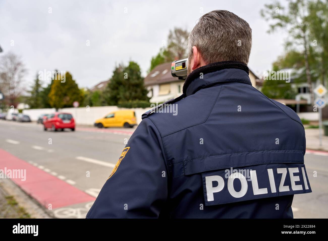 Augusta, Baviera, Germania - 19 aprile 2024: Maratona di autovelox in Baviera. Controllo degli autovelox da parte della polizia di Augusta. Un agente di polizia misura la velocità con un dispositivo di misurazione laser in una zona di 30 km/h *** Themenbild Blitzermarathon a Bayern. Radarkontrolle der Polizei ad Augusta. Ein Polizist misst die Geschwindigkeit mit einem laser Messgerät in einer 30 km/h zona Foto Stock