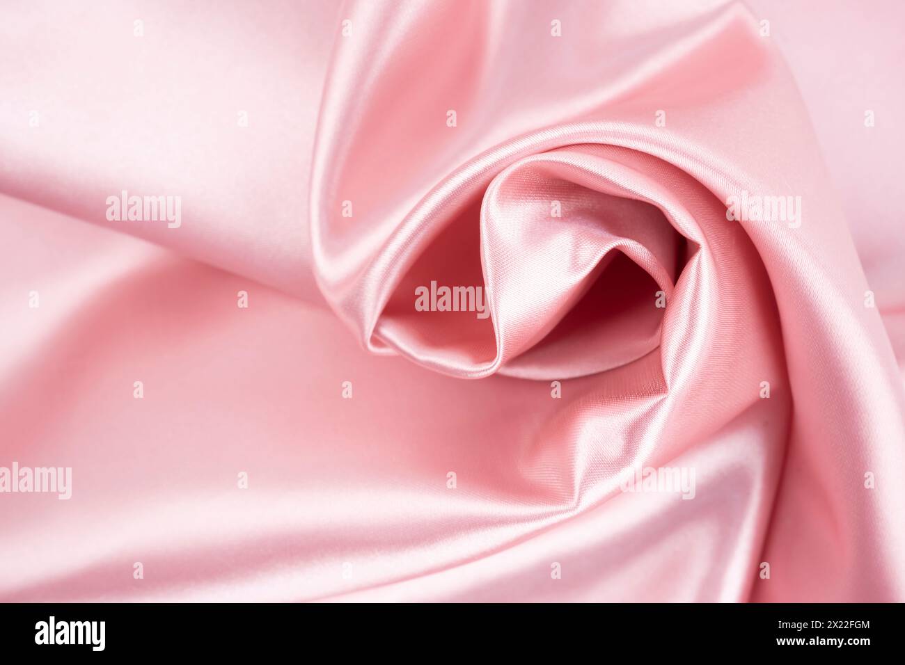 Tessuto in twill ondulato satinato di seta colore rosa. Foto Stock