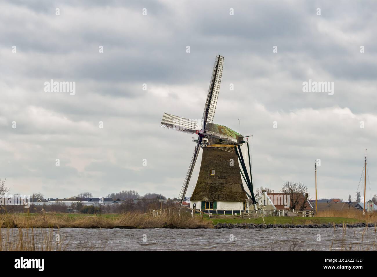 Vista dello storico Veendermolen con il cottage di miller sul seno della Weide AA vicino al villaggio olandese di Roelofarendsveen contro la B. Foto Stock