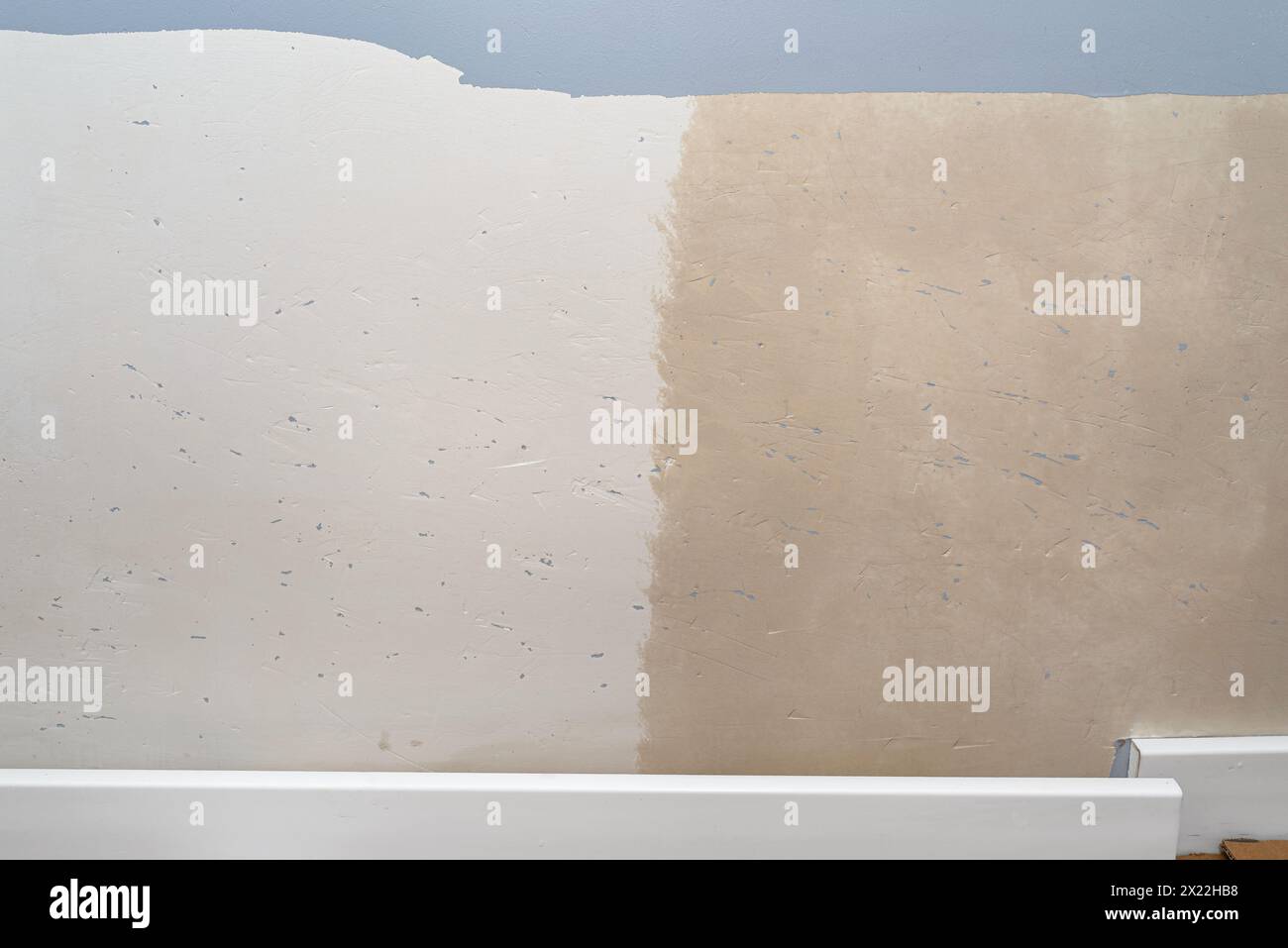 Preparazione di pareti danneggiate e fori per la verniciatura, graffiate da artigli di cane, applicazione di uno strato di adescamento con un rullo per pittura. Foto Stock