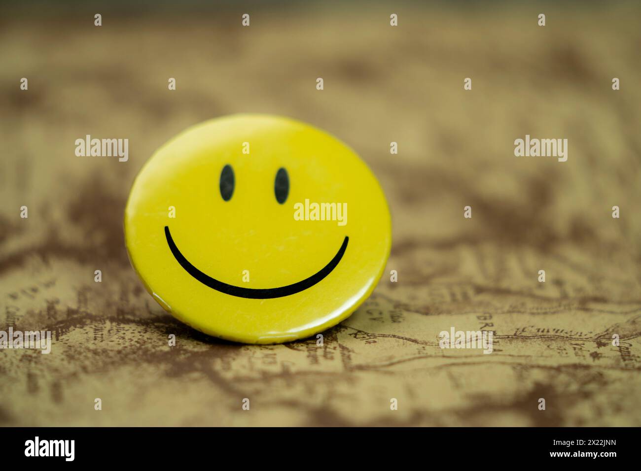 Faccia gialla con sorriso rotondo sullo sfondo della mappa Foto Stock