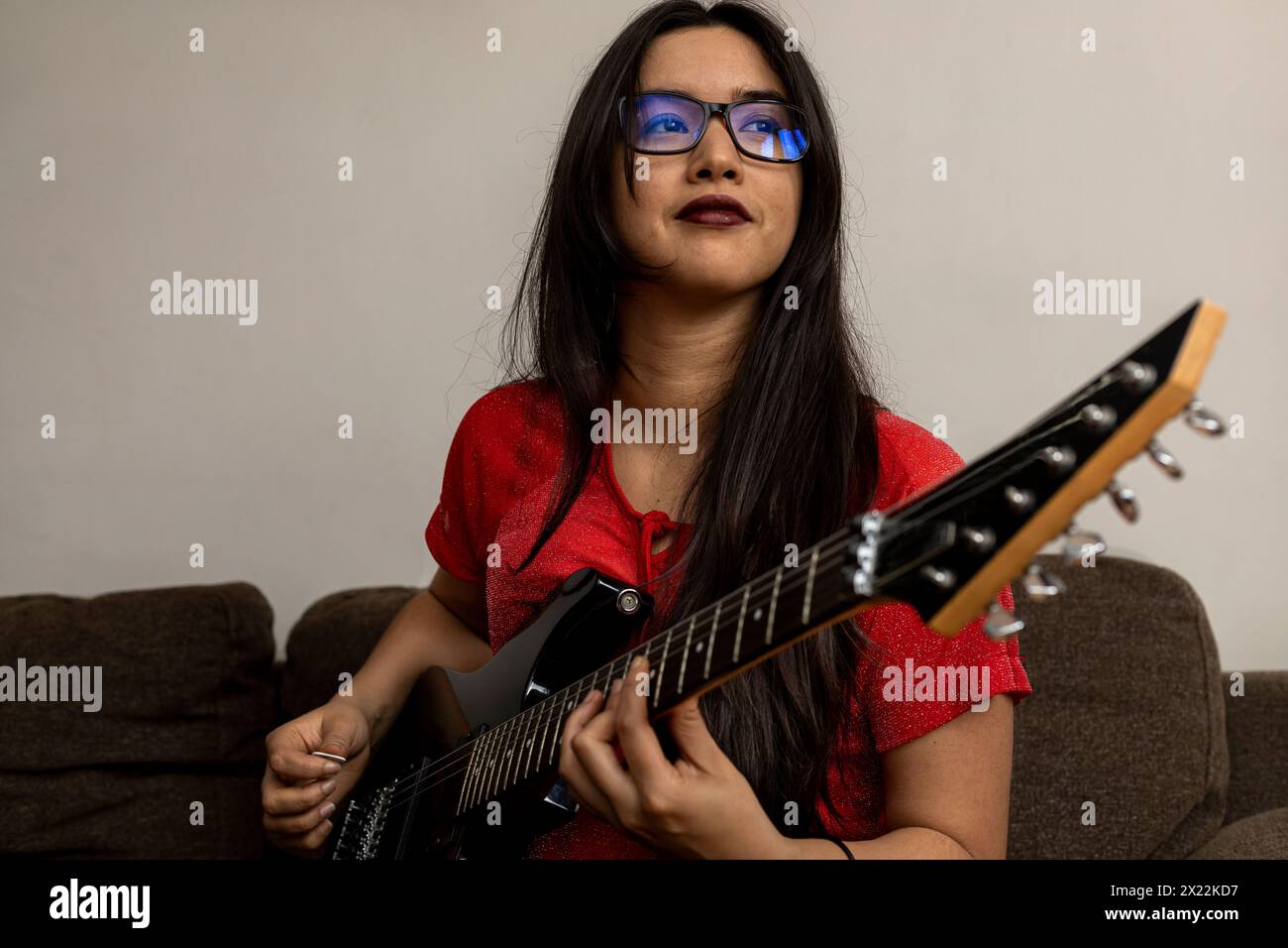 Ritratto della giovane musicista latinoamericana con la sua chitarra elettrica. Concetto musicale Foto Stock