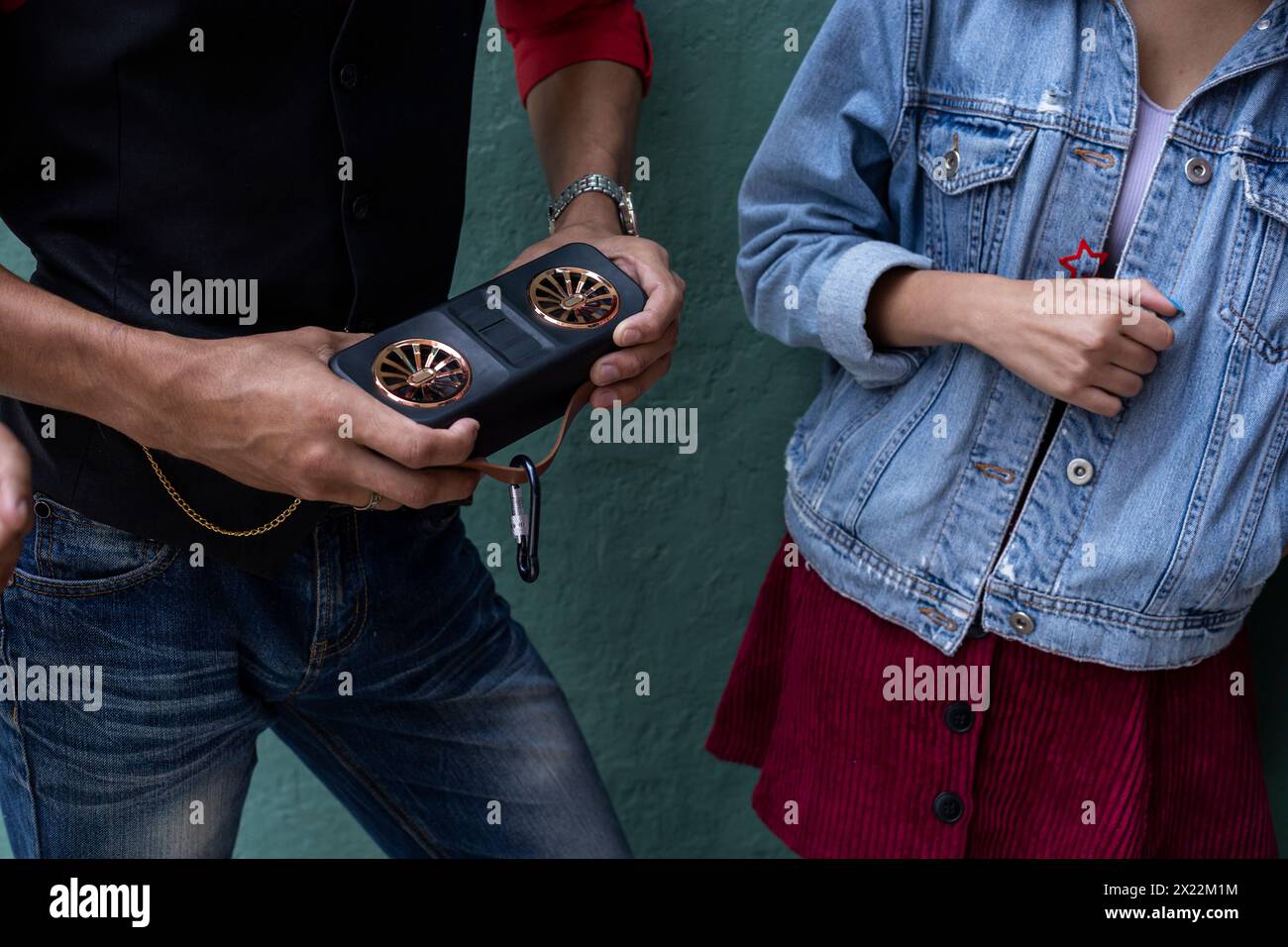 un giovane irriconoscibile ascolta la musica mentre tiene in mano un altoparlante Foto Stock