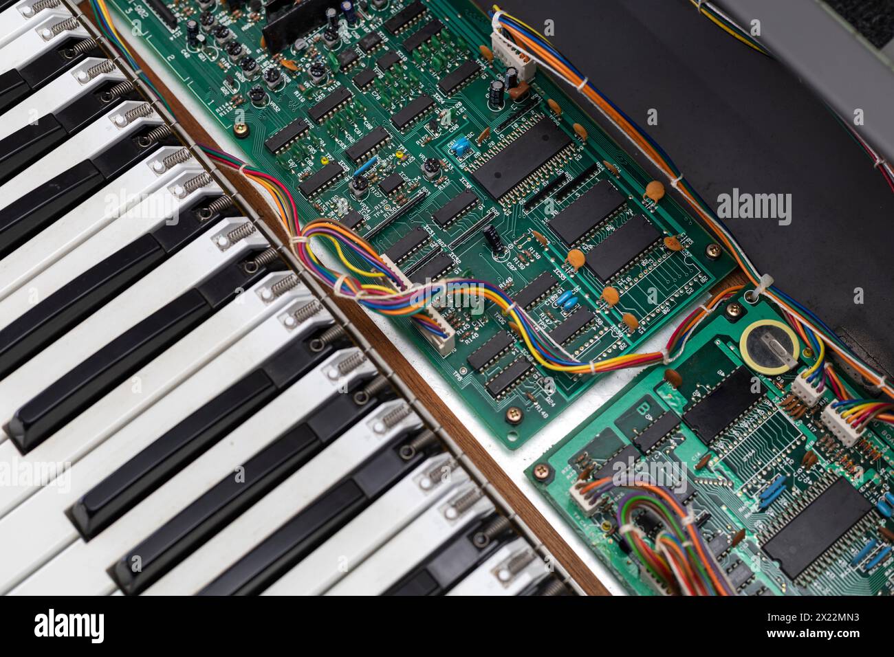 Vista di una scheda per la riparazione di circuiti elettronici e dei suoi componenti di un pianoforte elettrico. Riparazione concettuale, elettronica Foto Stock