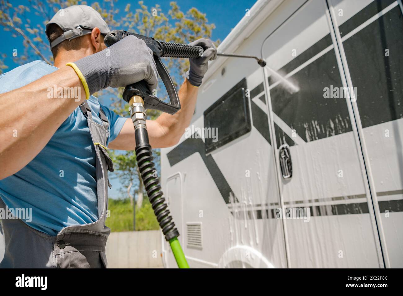 Camper proprietario di camper che lava il suo veicolo prima della stagione estiva Foto Stock