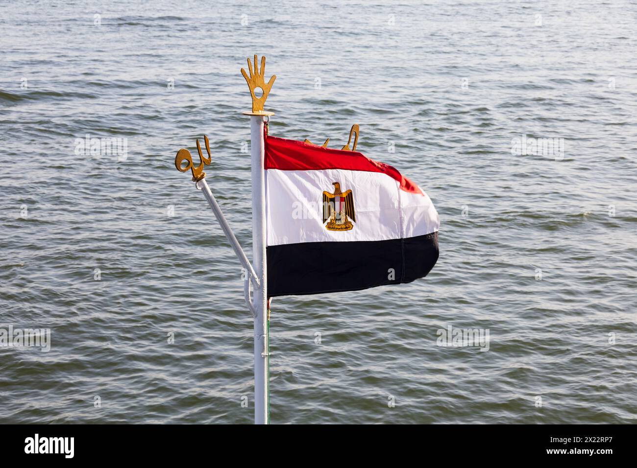 Bandiera nazionale egiziana alla testa dell'albero di una nave da crociera sul nilo, con emblemi simbolici. Fiume Niel, Assuan, Egitto. Foto Stock