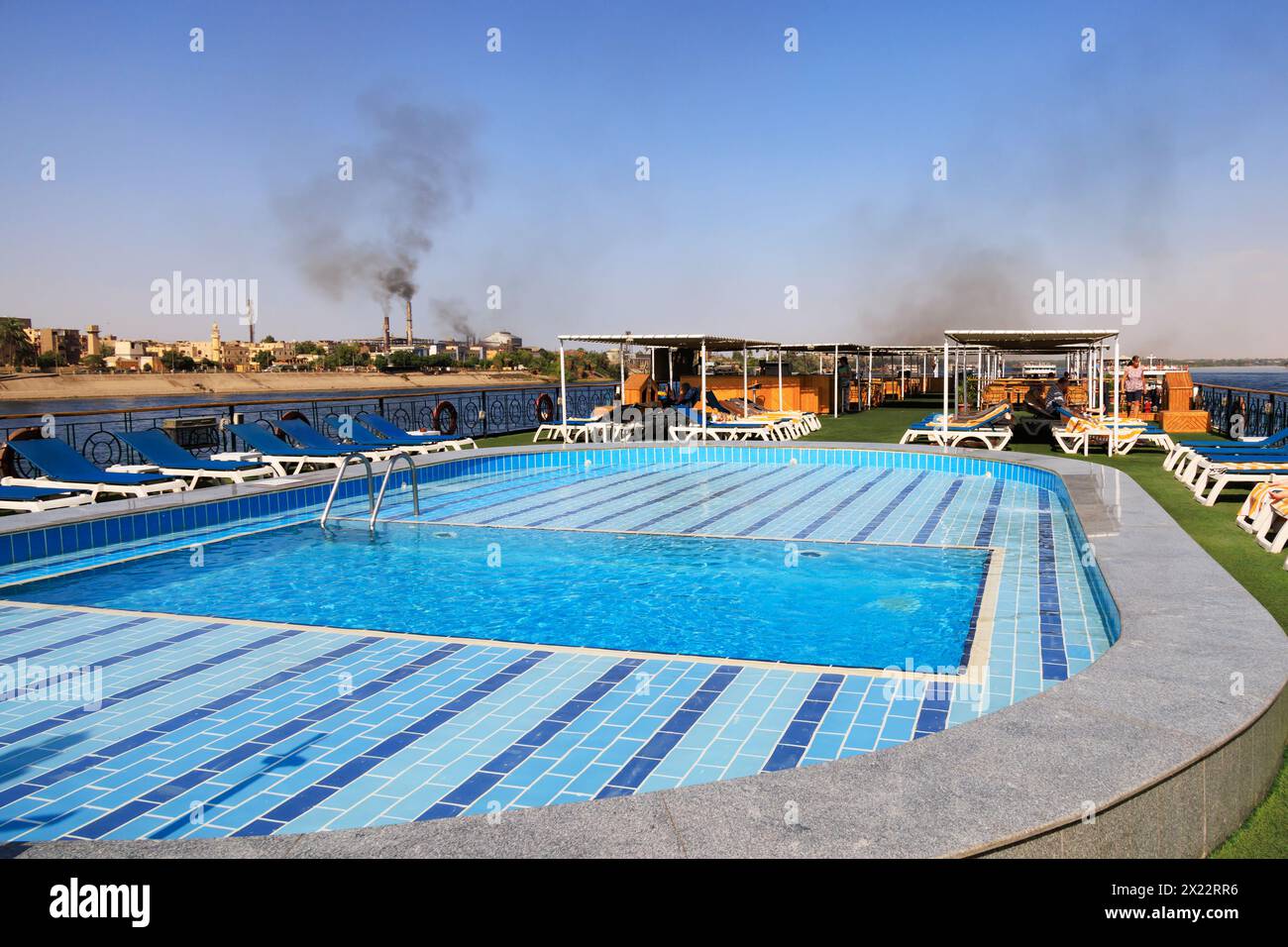 Terrazza solarium su una nave da crociera sul Nilo che mostra la piscina e l'inquinamento della fabbrica di zucchero, Kom Ombo, Assuan, Egitto Foto Stock