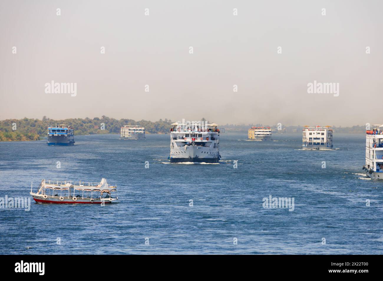 Navi da crociera Flottilla del Nilo con traghetto locale che attraversa i suoi sentieri. Fiume nilo tra Luxor e Assuan, Egitto Foto Stock