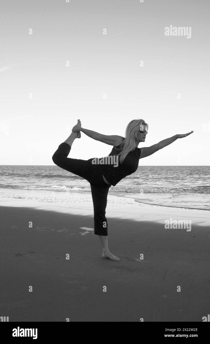 Pretty Young Woman pratica yoga a Hunting Island Beach South Carolina USA Foto Stock