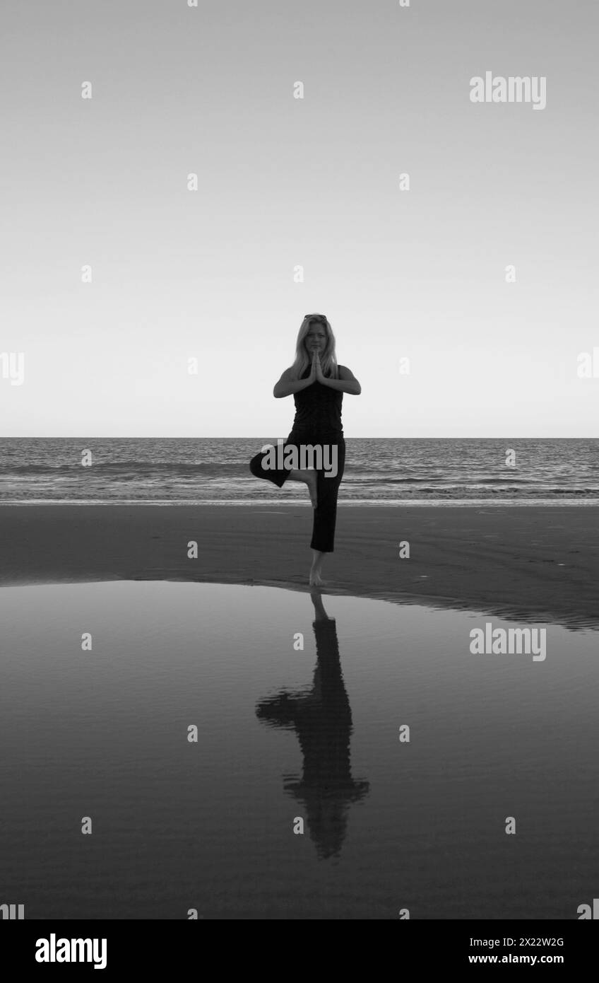 Pretty Young Woman pratica yoga a Hunting Island Beach South Carolina USA Foto Stock