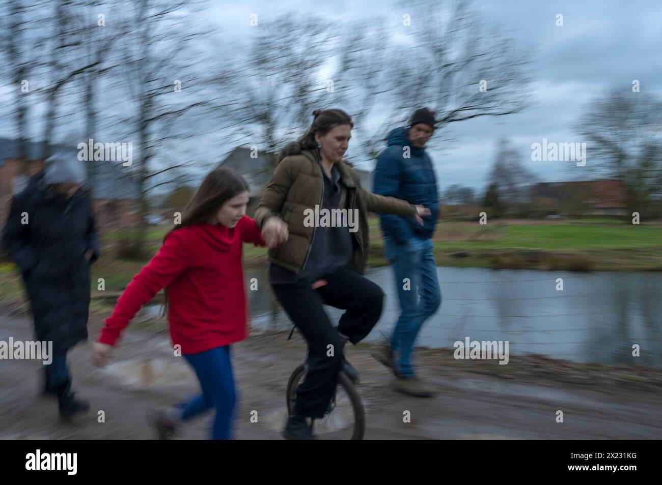 Passeggiata in famiglia, una giovane donna con un monociclo, movimento sfocato, Meclemburgo-.Vorpommern, Germania Foto Stock