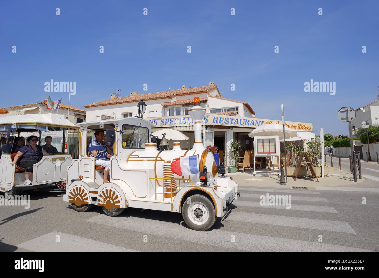 Ferrovia o treno lento di fronte a un ristorante, Les Saintes-Maries-de-la-Mer, Camargue, Bouches-du-Rhone, Provence-Alpes-Cote d'Azur, a sud di Foto Stock